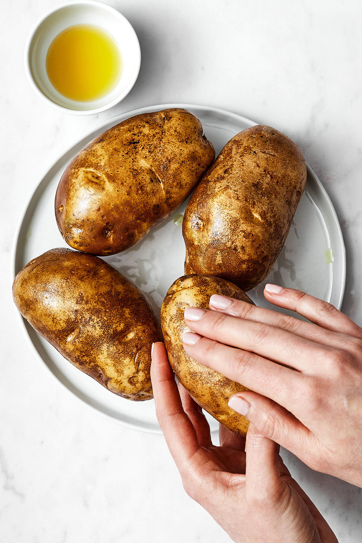 Rubbing olive oil on potatoes