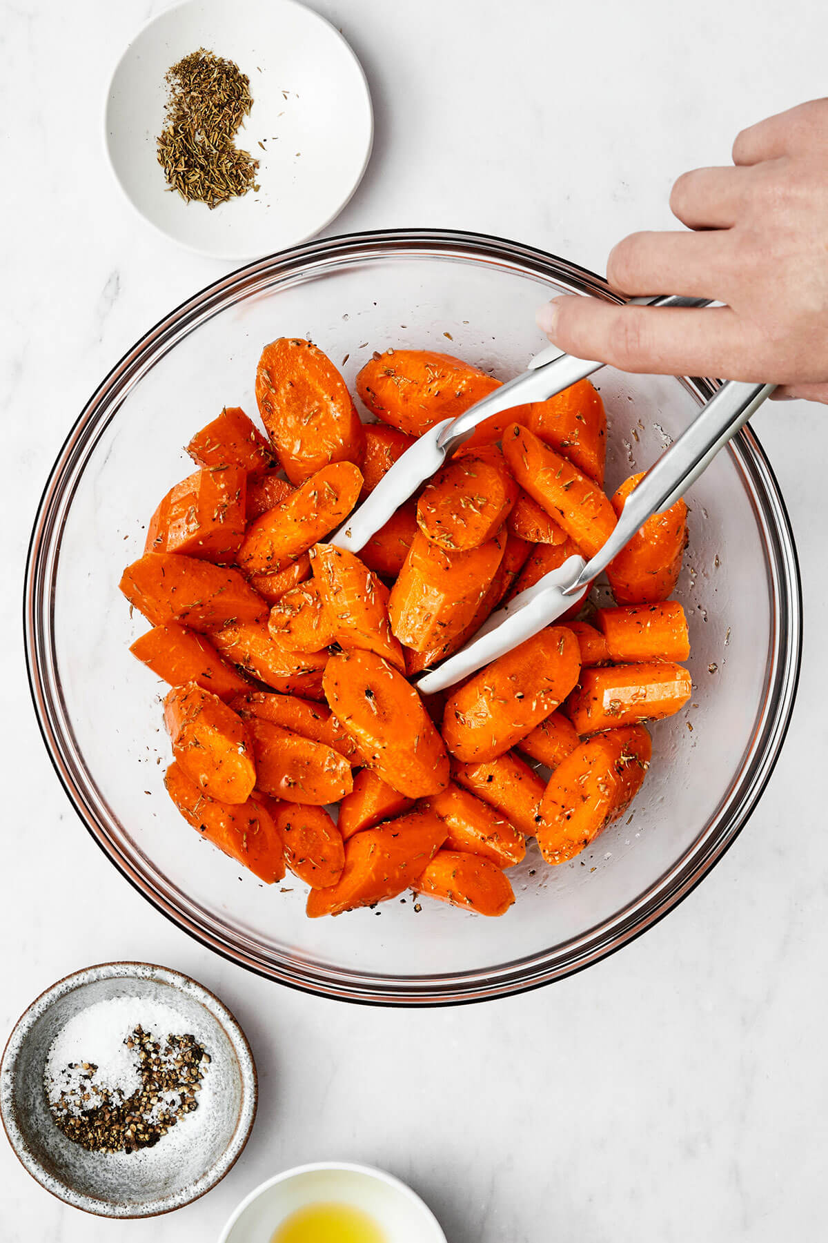 Tossing carrots with oil and seasoning