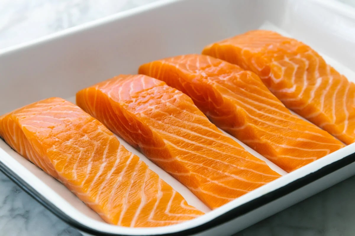 Raw salmon filets in a baking dish.