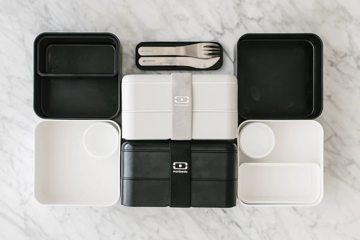 Black and white bento box containers on a countertop.