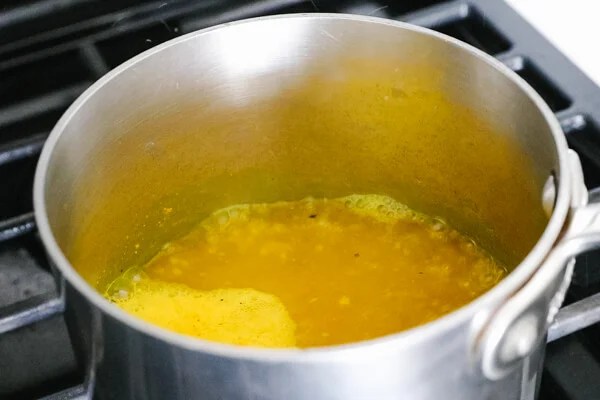 Turmeric tea ingredients simmering in a pot.