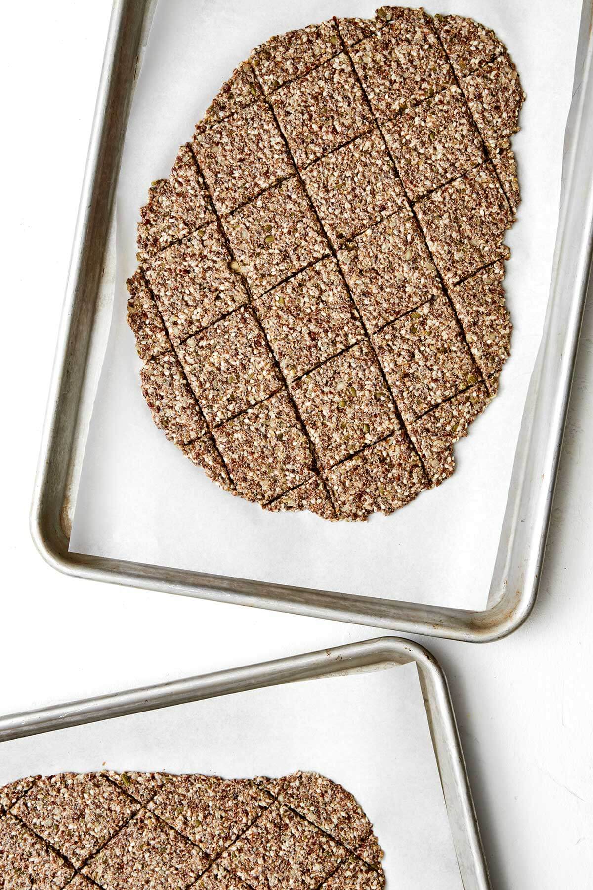 Crunchy, flavorful, and full of nutrients, these healthy seed crackers will soon be your favorite snack. Plus, they’re naturally gluten-free! Rolled out seed crackers on a sheet pan.