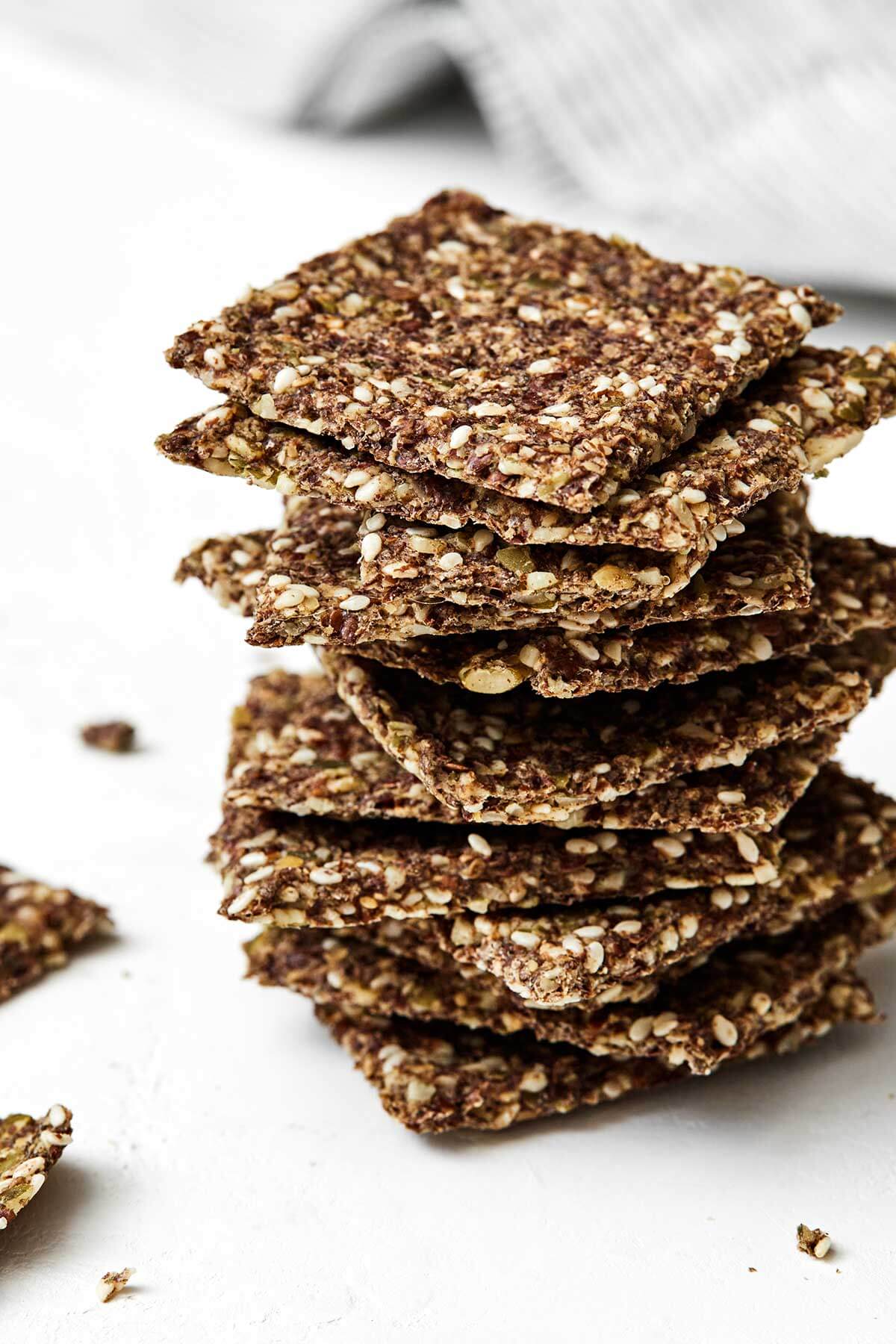 Crunchy, flavorful, and full of nutrients, these healthy seed crackers will soon be your favorite snack. Plus, they’re naturally gluten-free! A pile of seed crackers.